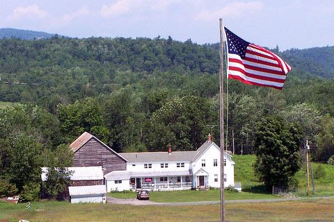 American Flag Flying Over Farmhouse